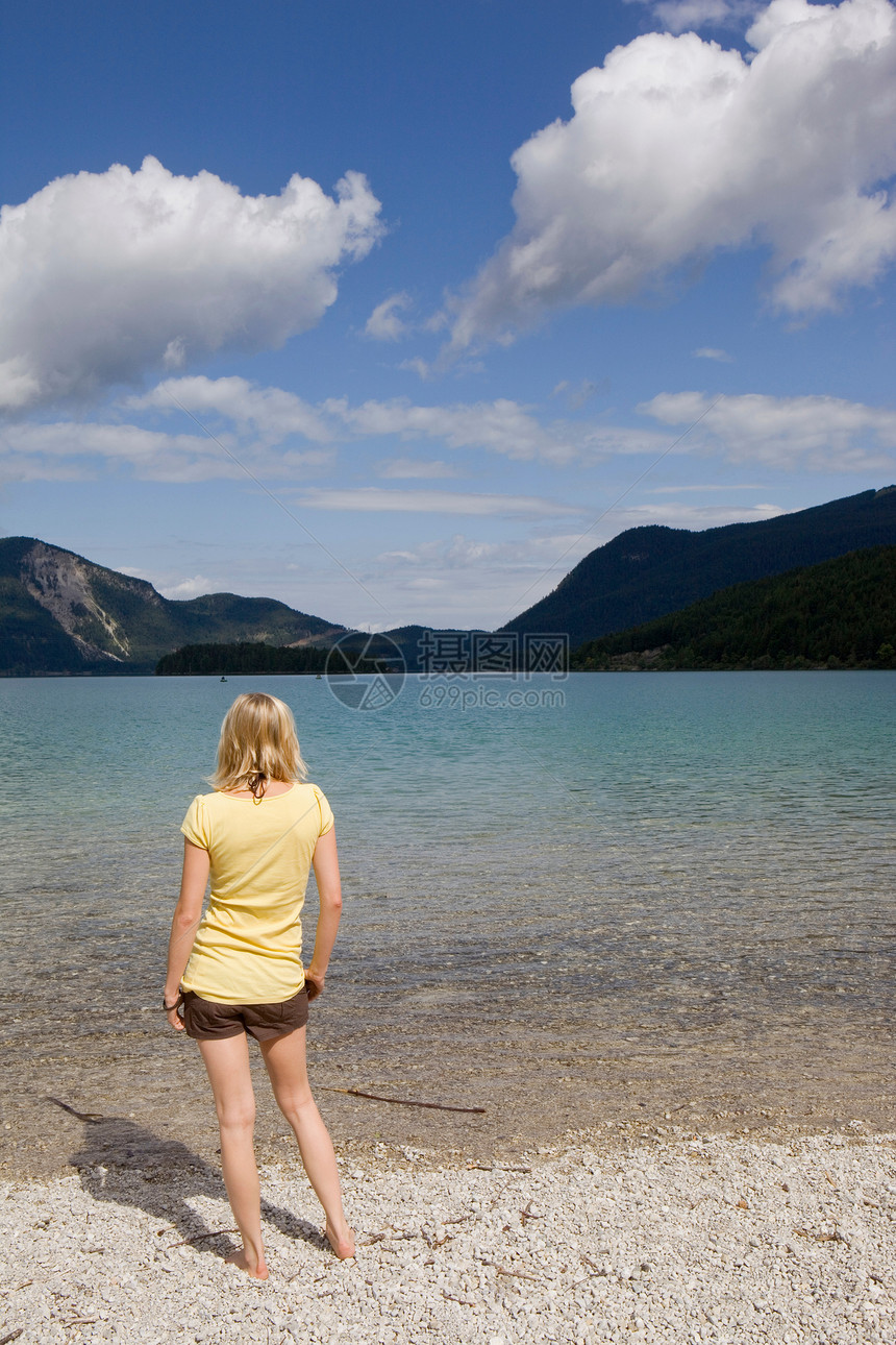 站在湖边的年轻女子图片