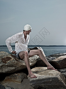 在岩石上坐着的男人图片