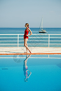 红色泳衣少女游泳池旁的年轻女子的肖像背景