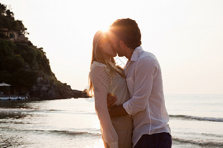 年轻夫妇在海滩上接吻假期高清图片素材