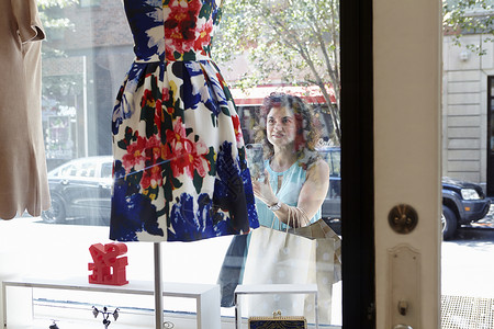 时尚精品店橱窗里的成熟女人图片