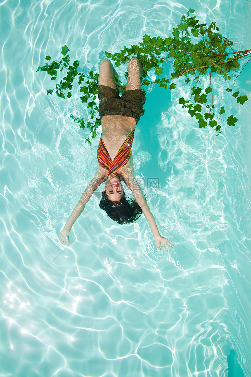 女人倒挂在游泳池的树枝上图片