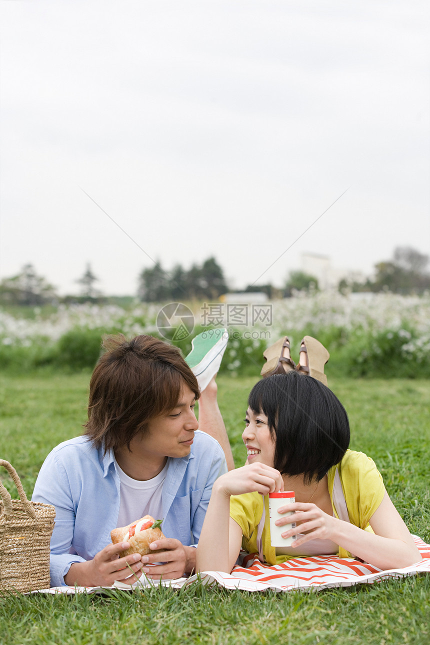 一对夫妇在草地上吃午饭图片