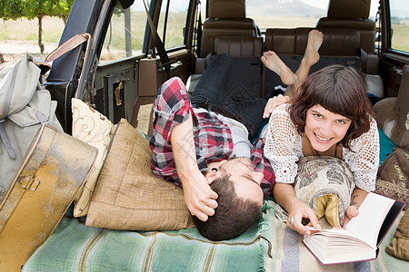情侣在SUV后面放松图片