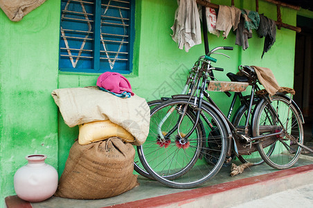 卡纳塔克迈索尔附近村舍外的自行车和麻袋破布图片