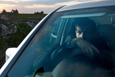 望天鹅风景区商人靠在车里的方向盘上背景