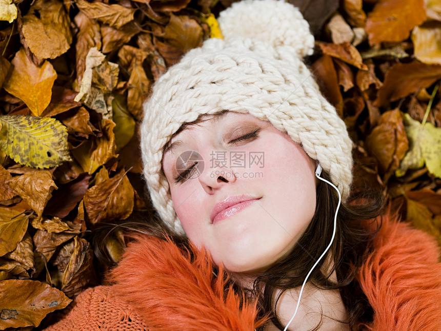 女人在秋叶上放松图片