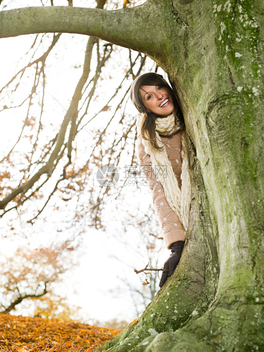 站在树后微笑的女人图片