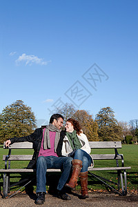 一对面对面坐在公园长椅上的夫妇高清图片