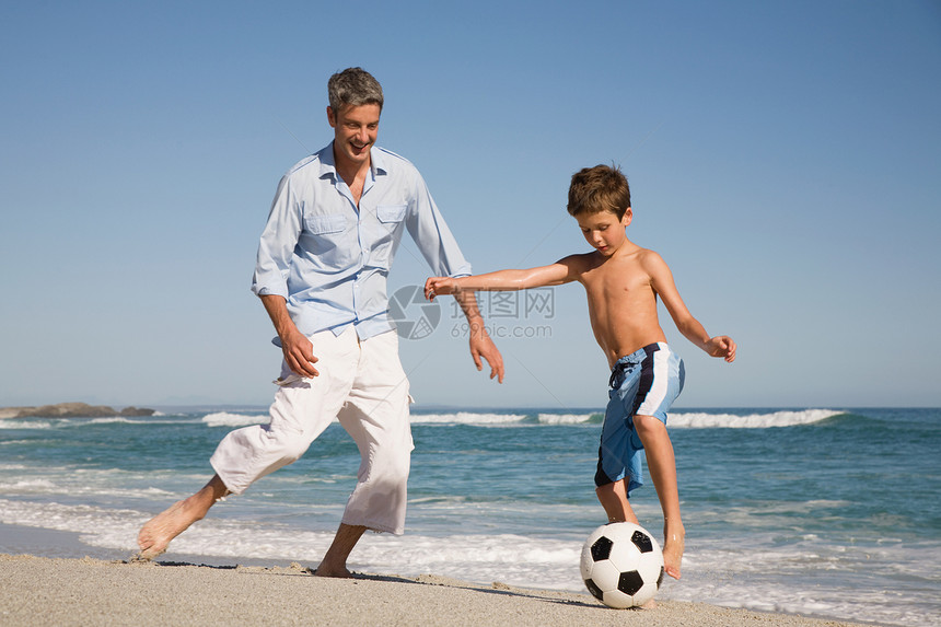 父子俩在海边踢足球图片