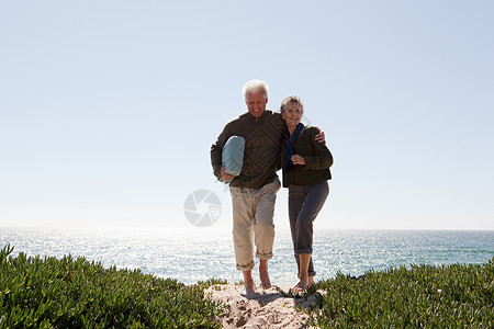 在沙丘上行走的成年夫妇图片