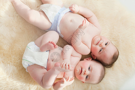 躺在羊皮地毯上的双胞胎女婴背景图片