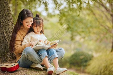 温馨母女坐在树下读书图片素材