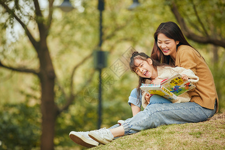 秋天树下温馨母女坐在树下读书背景