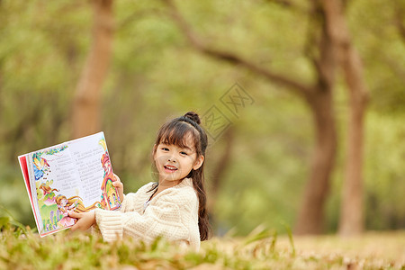 小女孩休闲小女孩户外看童话书背景
