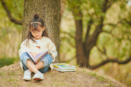 秋天树木背景小女孩户外看童话书背景
