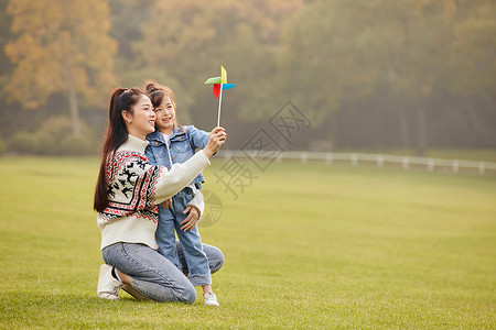 可爱母女草坪上玩风车踏青高清图片素材