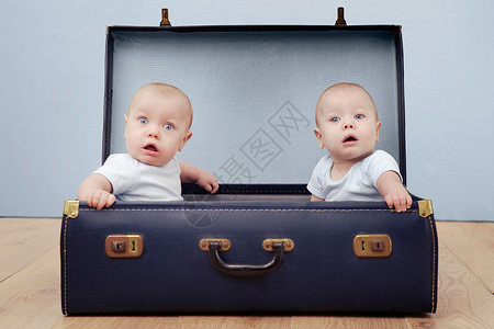 两个男婴坐在手提箱里图片素材