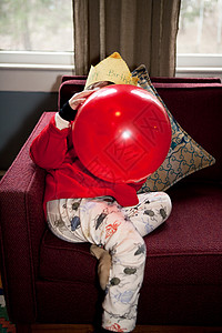 吹起红色生日气球的男孩图片