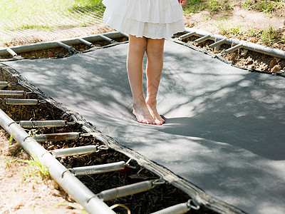 在蹦床上蹦跳的女孩，低矮的部分背景图片