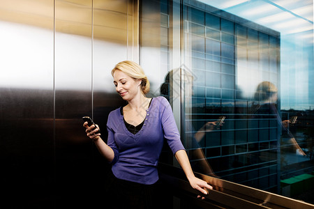 电梯里的女人，带着手机图片素材