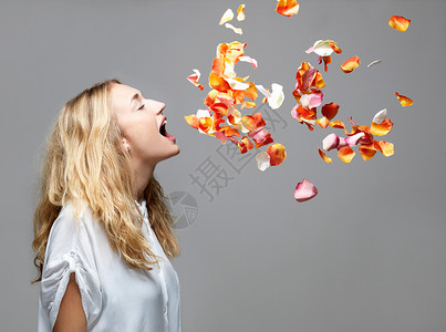 少妇张开嘴吃飘浮在半空中的花瓣背景图片