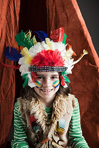 小男孩穿着美国土著的服装戴着提皮背景图片