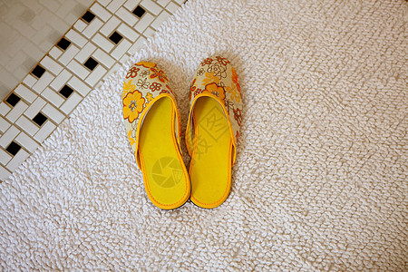 地毯上的一双黄色拖鞋背景图片