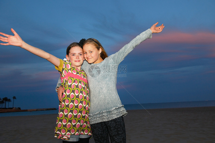 海滩上与日落拍照的女孩图片