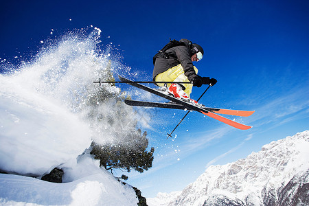 滑雪地域男子滑雪运动员在山上半空背景