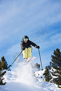 男子滑雪运动员半空在山坡上背景图片