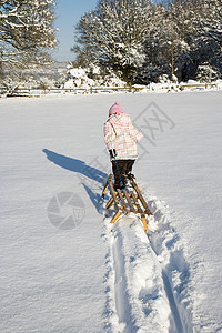 在雪地里拉雪橇的小女孩旅行高清图片素材