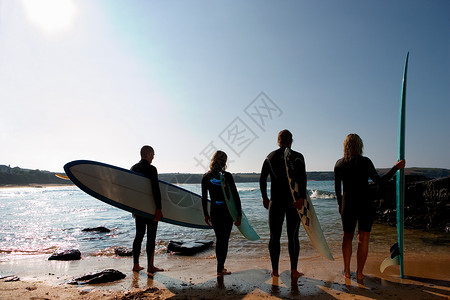 四个人拿着冲浪板准备冲浪湿衣服高清图片素材