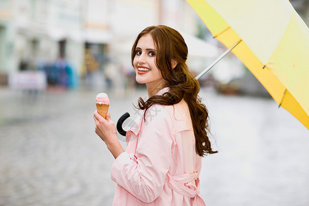女孩在雨中享受冰淇淋开心高清图片素材