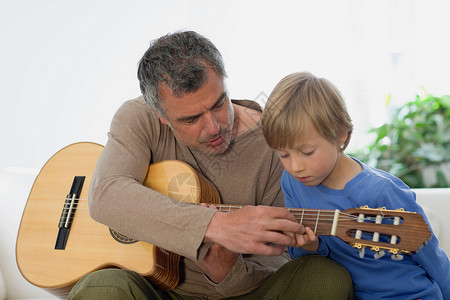 男子教小孩弹吉他图片