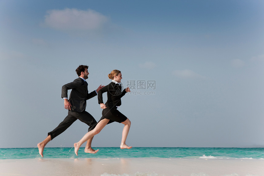 在海滩上跑步的商人图片