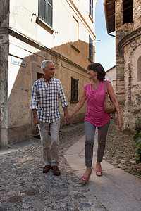 在鹅卵石街道上行走的老年夫妇图片