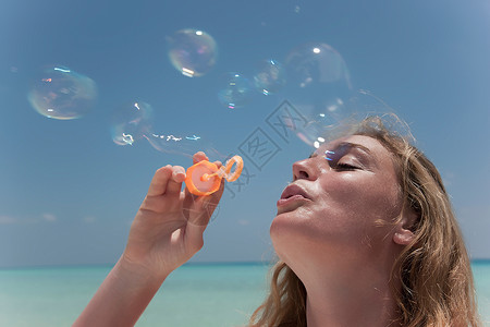 女人在沙滩上吹泡泡图片