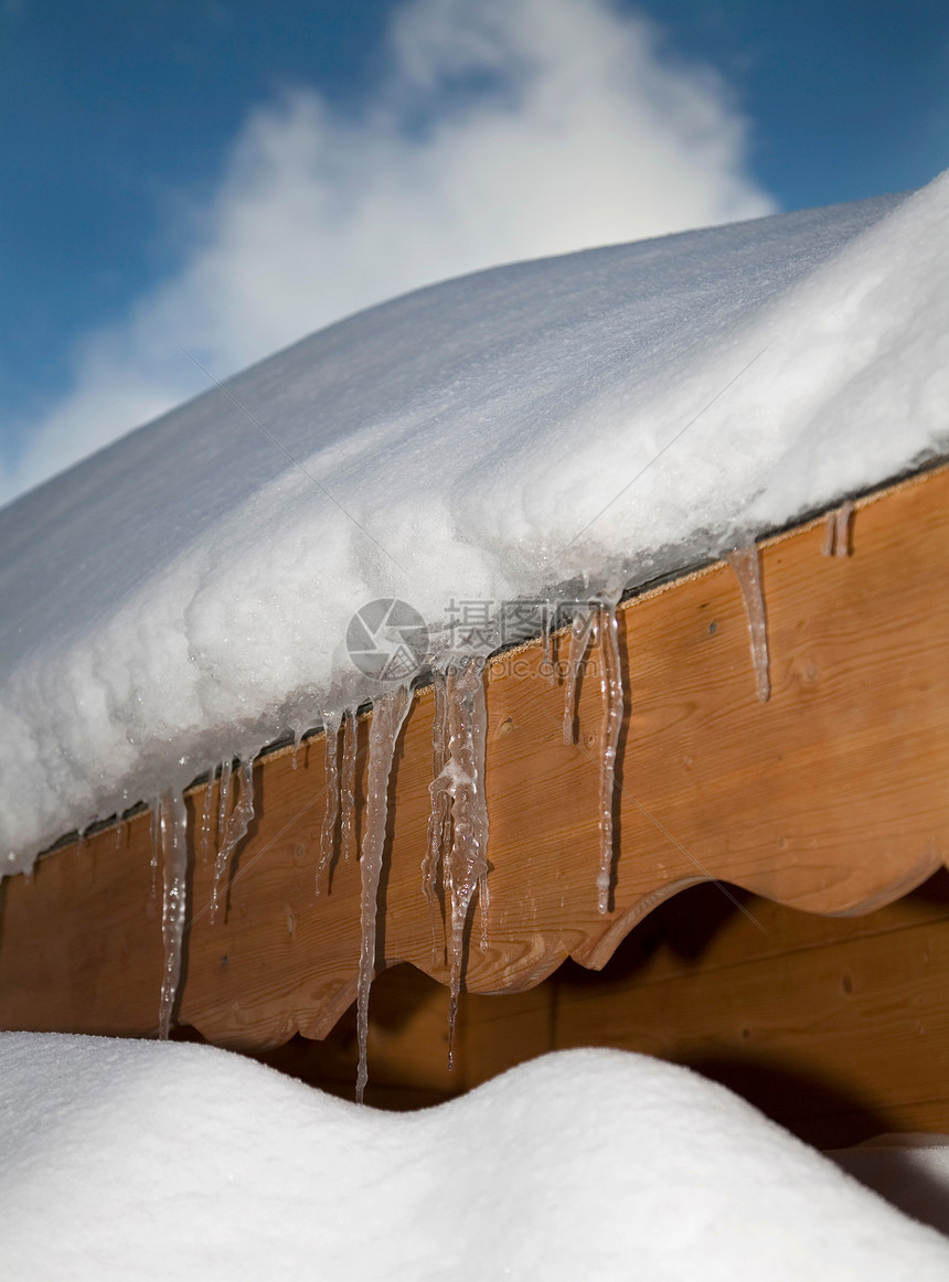 雪盖屋顶上的冰柱图片
