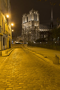 法国巴黎圣母院和鹅卵石街道夜景图片