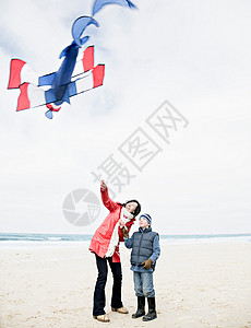 沙滩上带风筝的男女图片