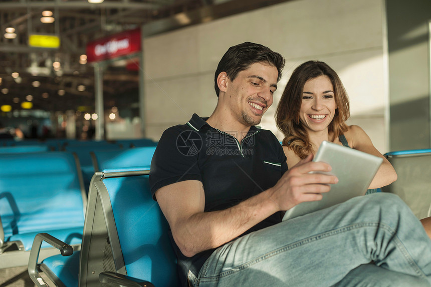 在机场候机厅的年轻夫妇图片