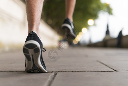 运动主义穿着运动鞋在人行道上跑步的年轻男性跑步者背景