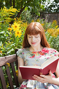 在花丛里看书的女人图片