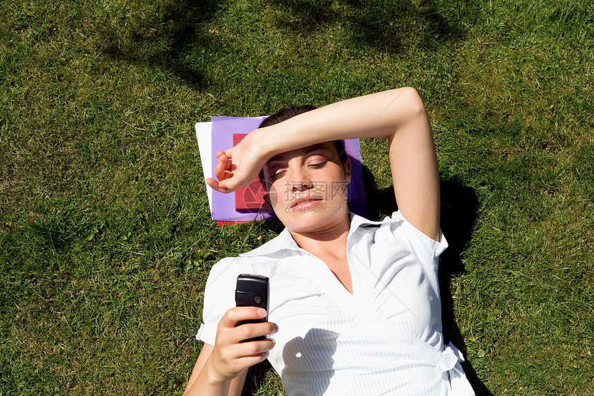 女商人躺在草地上发短信图片