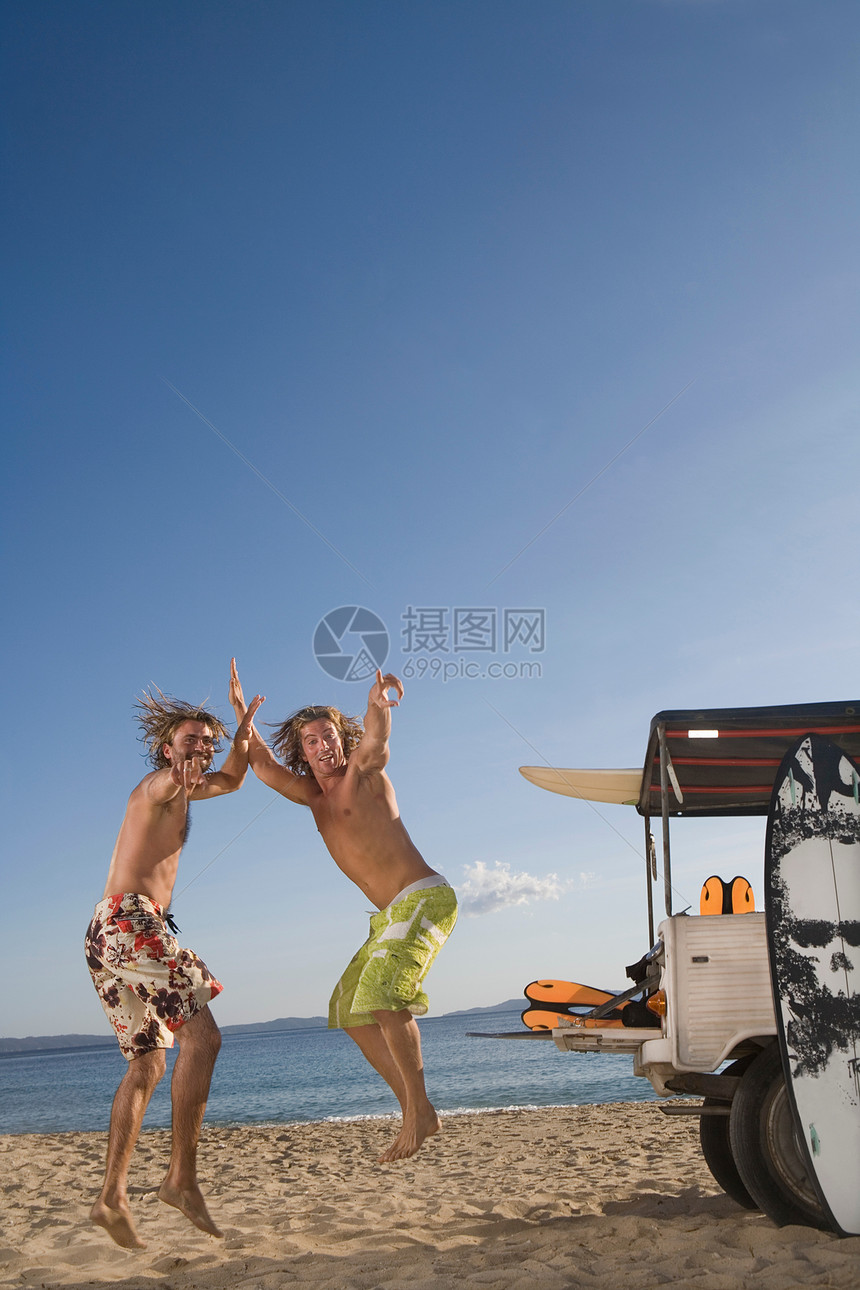 海边吉普车旁跳跃的年轻人图片