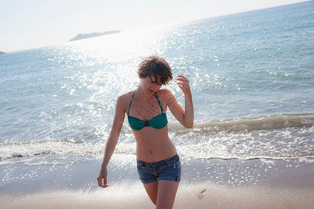 穿比基尼的女人在海滩上散步图片