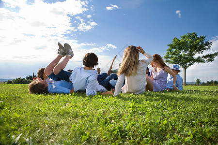 少年组在公园里躺在草地上亲密高清图片素材