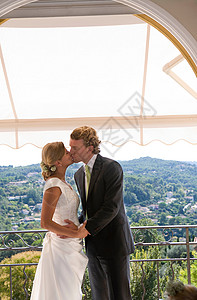 新娘新郎在阳台上接吻图片