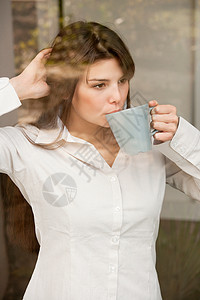 女人靠着窗户喝茶图片